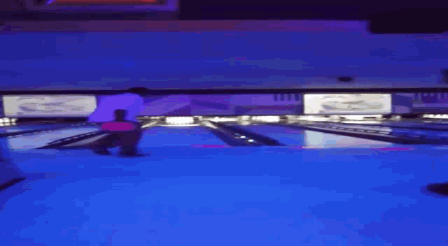 a bowling alley with a blue light shining on the floor