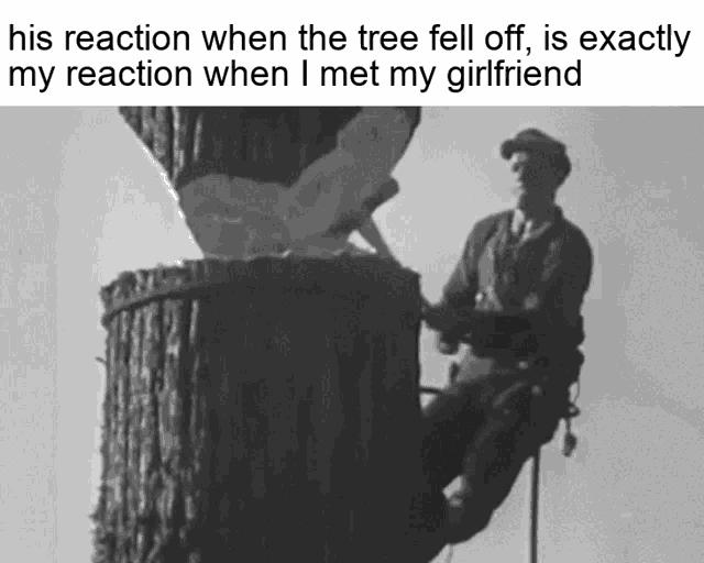 a black and white photo of a man climbing up a tree