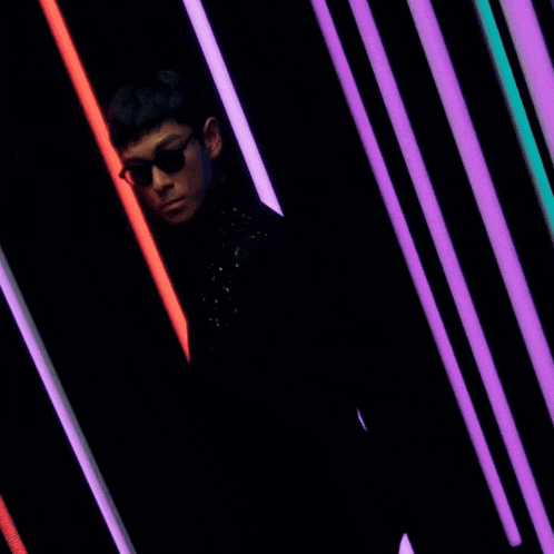 a man wearing sunglasses and a black jacket with stars on it