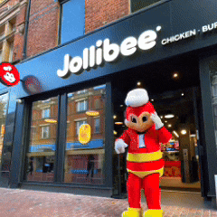 a jollibee chicken restaurant with a mascot in front