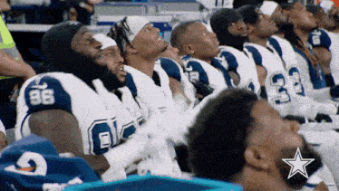 a group of cowboys players are sitting in a row with the number 88 on their jerseys