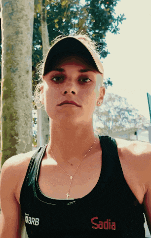 a woman wearing a sadia tank top and a hat