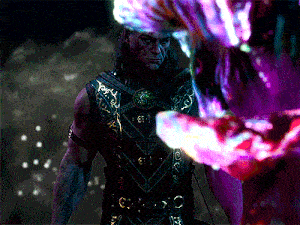a man in a purple and gold outfit stands in front of a monster