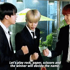a man in a suit says let 's play rock paper scissors and the winner will decide the name ..