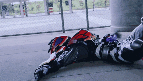 a person laying on the ground wearing a helmet that says ' x ' on it