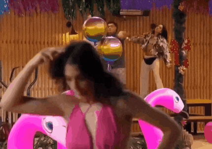 a woman in a pink bikini is standing next to a pink flamingo pool float