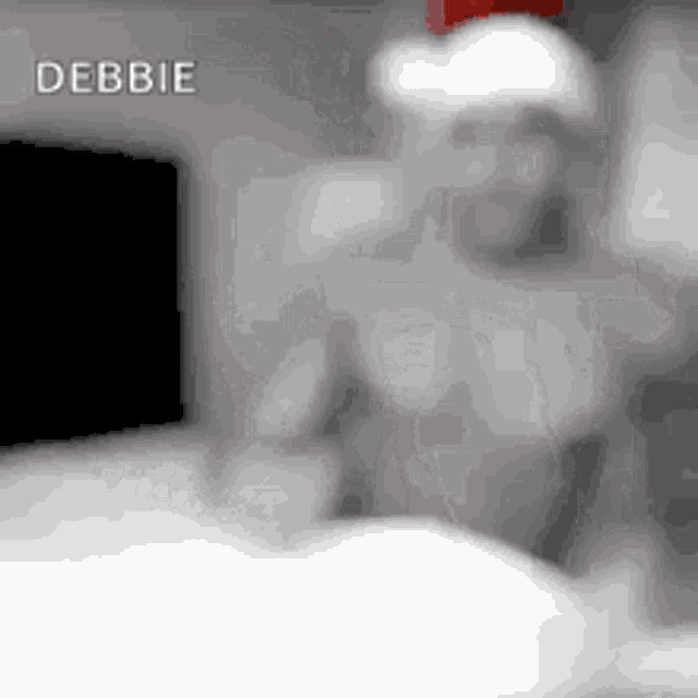 a person wearing a santa hat is standing in front of a tv .