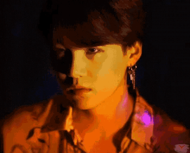 a close up of a person 's face with a yellow shirt and earrings