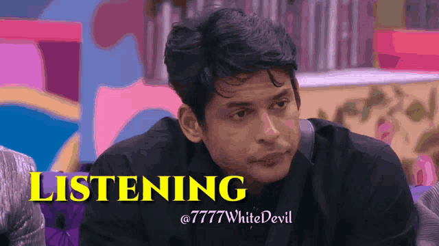 a man in a black suit is listening to something