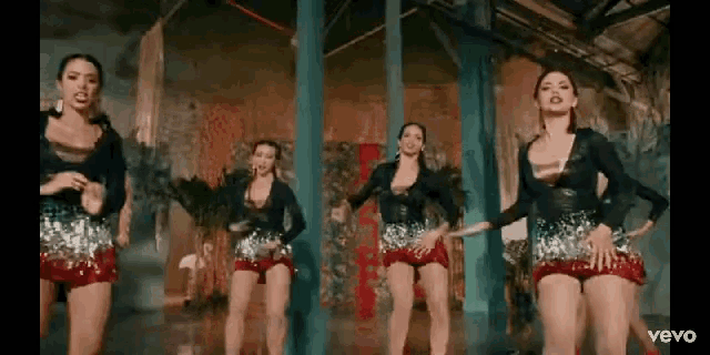 a group of women are dancing together in a room in a video .