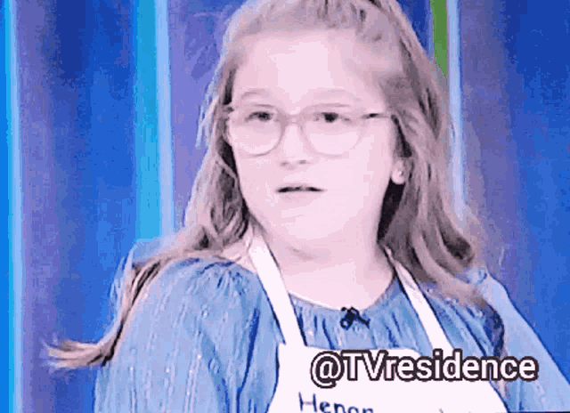 a girl wearing glasses and an apron with the words @tvresidence written on it