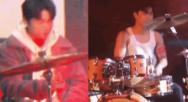 a man is playing drums on a stage while another man looks on .
