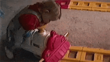a child is playing with a toy train on a train track .