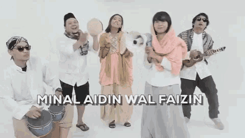 a group of people standing next to each other with the words minal aidin wal faizin written above them