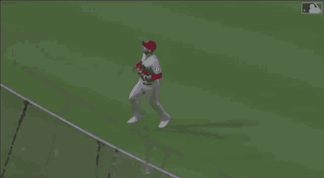 a baseball player is running on the field while holding a glove .