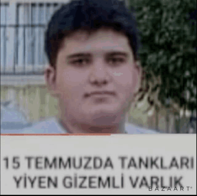 a man is standing in front of a sign that says `` 15 temmuzda tanklari yiyan gizemli varlik '' .