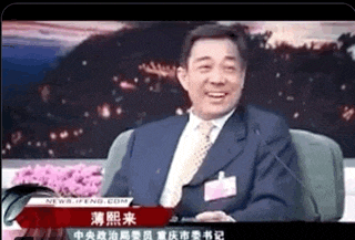a man in a suit and tie is sitting in front of a microphone and smiling ..