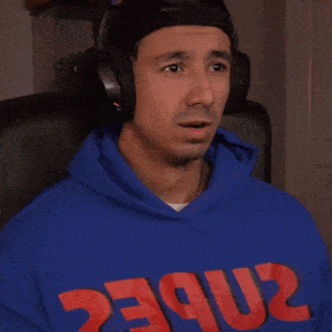 a man wearing headphones and a blue hoodie that says 2nbec on it