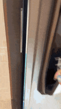 a close up of a refrigerator door with a reflection of a person in it