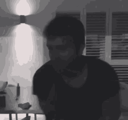 a man with a beard is standing in a dark room