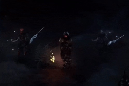 a group of people standing in the dark holding sticks