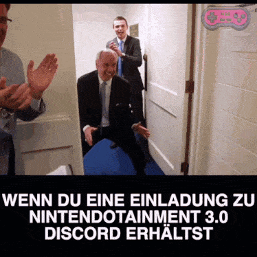 a man in a suit and tie is standing in a hallway with other men applauding him