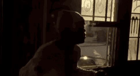 a silhouette of a person standing in front of a window .