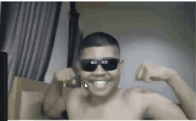 a shirtless man wearing sunglasses is flexing his muscles in a video call .