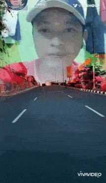 a man wearing a hat is driving down a road .