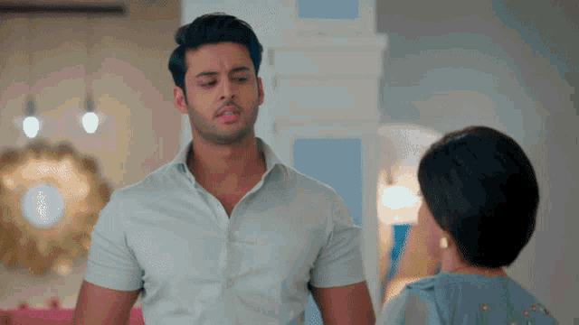 a man in a white shirt is standing next to a woman in a blue dress