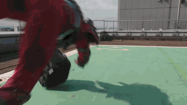 a person in a red suit is doing a trick on a green mat