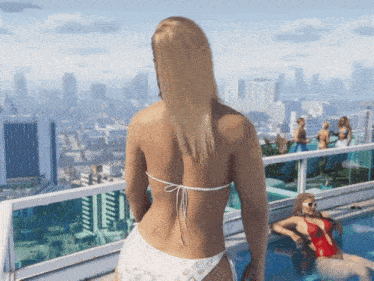 a woman in a bikini is standing on a balcony overlooking the city