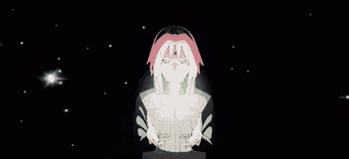 a girl with pink hair is standing in a dark room with her hands folded in front of her chest .
