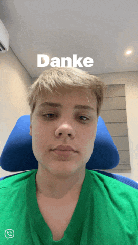 a young man wearing a green shirt with the word danke on the top of his head