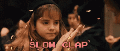 a little girl is clapping her hands with the words slow clap behind her .