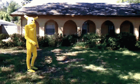 a person in a yellow suit is standing in front of a house with arches