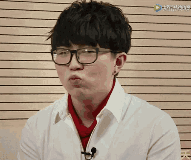 a man wearing glasses and a red scarf is making a face
