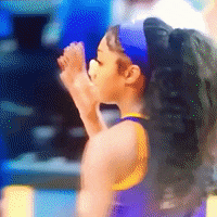 a blurred image of a person wearing a purple and yellow tank top