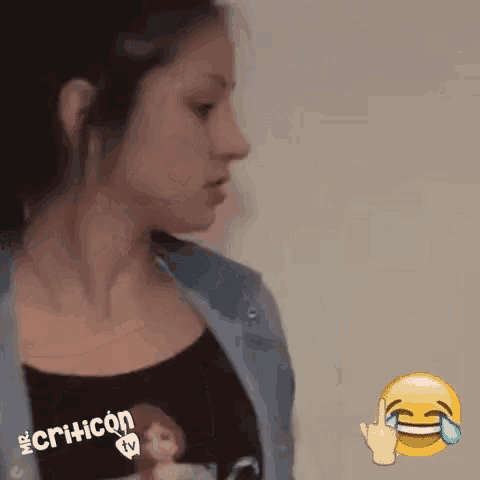 a woman wearing a t-shirt with a doll on it is laughing and crying .
