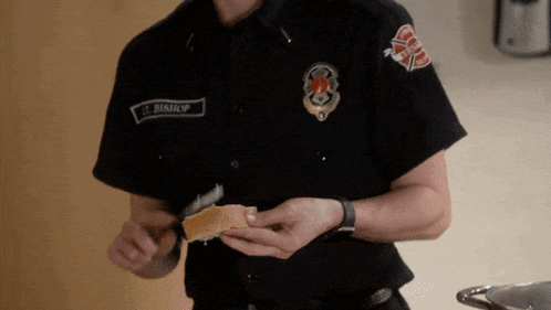 a firefighter named j. bishop is holding a piece of bread in his hand