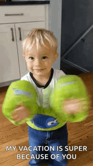 a young boy is wearing a pair of green life jackets .