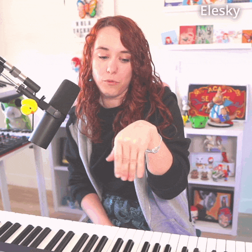 a woman playing a keyboard with the name elesky on the bottom left