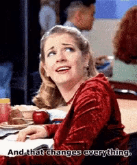 a woman in a red dress is sitting at a desk with an apple and the words " and that changes everything " below her