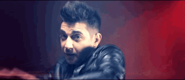 a man in a leather jacket is holding something in his hands