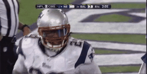 a football player wearing a helmet stands on the field during a game sponsored by cbs