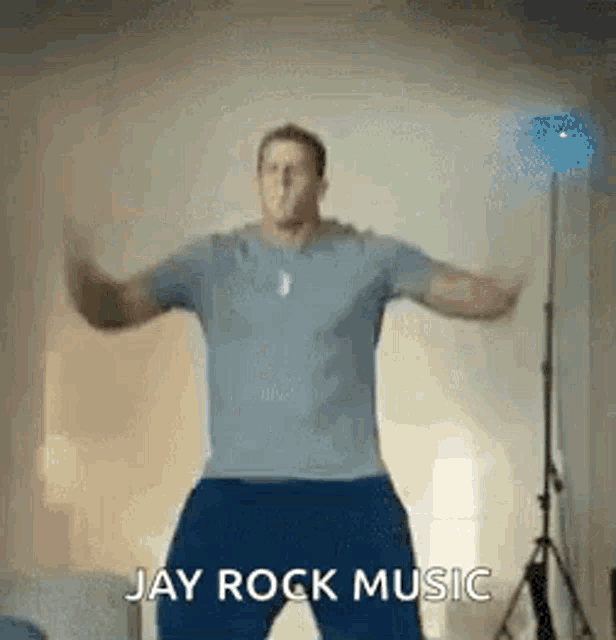 a man is dancing in a living room with the words `` jay rock music '' written below him .