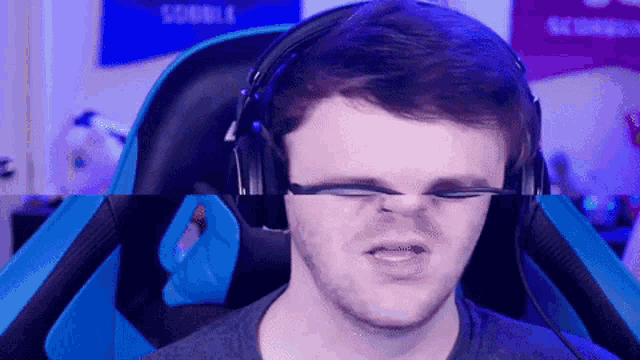 a man wearing headphones and glasses is making a funny face .