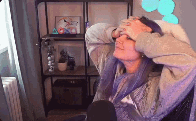 a woman sitting in front of a playstation sign