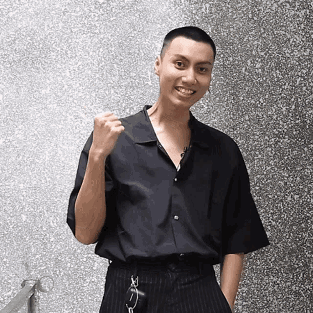 a young man wearing a black shirt and striped pants is smiling