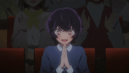 a girl with purple hair and pink eyes is sitting in a theater